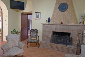 a living room with a fireplace and two chairs at Conte Spencer in Casertavecchia