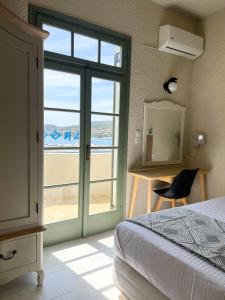 1 dormitorio con 1 cama y puerta corredera de cristal en Kores Aegina en Agia Marina Aegina