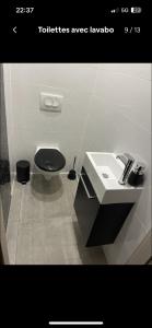 a bathroom with a black toilet and a sink at Cosy loft 2 ch in Talange