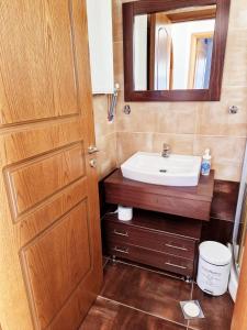 een badkamer met een wastafel en een spiegel bij Elaia country living in Galatas