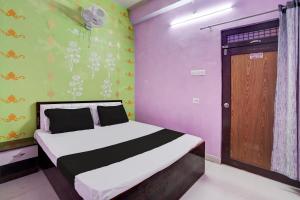 um quarto com uma cama e uma porta de madeira em OYO Flagship Hotel Divy inn em Prayagraj
