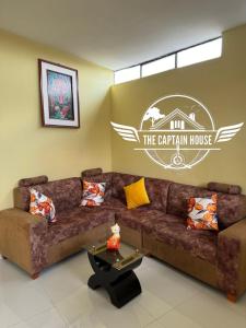 a living room with a brown couch and a table at The Captain House in Pucallpa