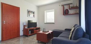 een woonkamer met een blauwe bank en een televisie bij Lukovo Seafront Apartments in Lukovo