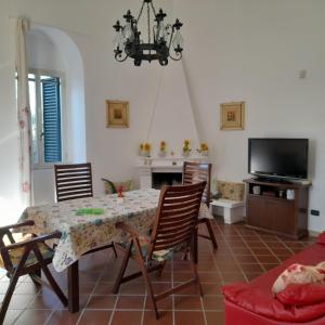 une salle à manger avec une table et des chaises et une télévision dans l'établissement Villa Hakuna Matata, à Andria
