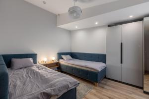 a bedroom with two beds and a blue couch at Lab1 House in Rīga