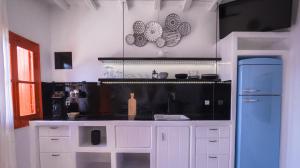 a kitchen with white cabinets and a blue refrigerator at Fisherman House in Klima