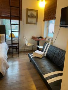 フィンチリーにあるUnique London Apartment, ideal for Long Staysのリビングルーム(黒い革張りのソファ、テーブル付)