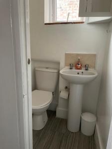 a white bathroom with a toilet and a sink at Unique London Apartment, ideal for Long Stays in Finchley