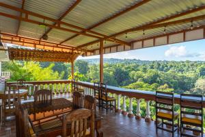 balcone con tavoli, sedie e vista sulle montagne di Villa Manolo Ocean and Forest View Hotel a Bahía Drake