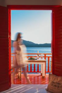 Eine Person geht an einem Tisch auf einem Deck vorbei in der Unterkunft Fisherman House in Klima