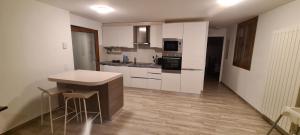 une cuisine avec des placards blancs et un comptoir dans l'établissement Casa Rossa Duplex, à Mezzovico