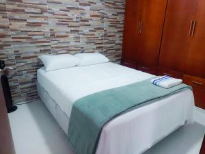 1 Schlafzimmer mit 2 Betten und Ziegelwand in der Unterkunft Un lugar encantador en San Vicente de Chucurí in San Vicente de Chucurí