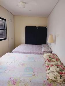 1 dormitorio con 1 cama grande y cabecero grande en Casa no Guarujá com 1 quarto en Bertioga