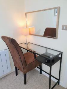 a desk with a chair and a mirror at THE PENTHOUSE AT REGENT HOUSE Light and airy top floor with lift access 1 bedroom en-suite luxury apartment ULTRA CENTRAL LOCATION in Harrogate