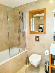 a bathroom with a tub and a toilet and a shower at THE PENTHOUSE AT REGENT HOUSE Light and airy top floor with lift access 1 bedroom en-suite luxury apartment ULTRA CENTRAL LOCATION in Harrogate