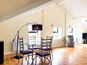 a dining room with a glass table and chairs at THE PENTHOUSE AT REGENT HOUSE Light and airy top floor with lift access 1 bedroom en-suite luxury apartment ULTRA CENTRAL LOCATION in Harrogate