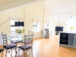 a dining room with a glass table and chairs at THE PENTHOUSE AT REGENT HOUSE Light and airy top floor with lift access 1 bedroom en-suite luxury apartment ULTRA CENTRAL LOCATION in Harrogate