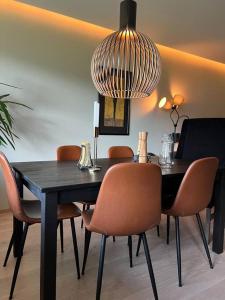 a dining room with a black table and chairs at Moderne leilighet med 2 soverom, 4 sengeplasser in Trondheim