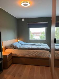 a bedroom with a large bed with a window at Moderne leilighet med 2 soverom, 4 sengeplasser in Trondheim
