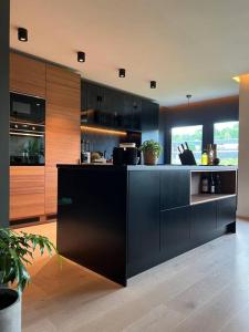 uma cozinha com armários pretos e um balcão preto em Moderne leilighet med 2 soverom, 4 sengeplasser em Trondheim