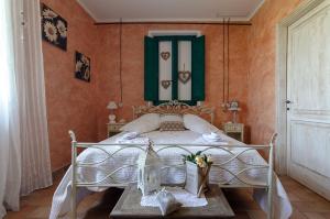Un dormitorio con una cama y una mesa con flores. en Agriturismo Tenuta Belvedere, en Belvedere Ostrense
