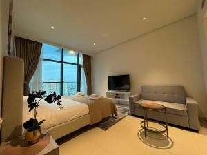 a bedroom with a bed and a couch and a tv at Seven Hotel & Apartments at the Palm Jumeirah Studio apartment with awesome view in Dubai