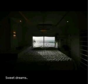 a dark room with a bed and a window at Top-floor Oceanfront Designer Condo In Bandra in Mumbai