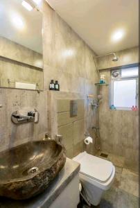 La salle de bains est pourvue d'un lavabo et de toilettes. dans l'établissement Top-floor Oceanfront Designer Condo In Bandra, à Mumbai