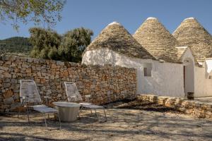 a group of chairs and a stone wall at Masseria Celeste in Fasano