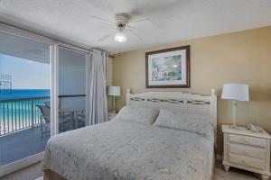 een slaapkamer met een bed en een balkon met uitzicht op de oceaan bij Pelican Beach 1612 condo in Destin