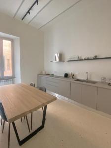 a large white kitchen with a wooden table in it at Veneto Suite 2 by SupaStays - King room in Rome