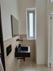 a bathroom with a sink and a mirror at Veneto Suite 2 by SupaStays - King room in Rome