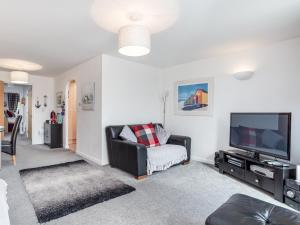 a living room with a couch and a tv at 14 Belvedere Court in Paignton