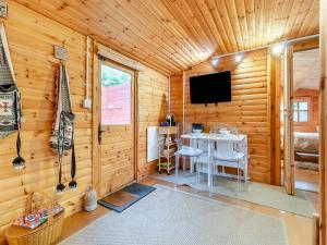 a room with a television in a wooden cabin at Easthorpe Retreat in Copford