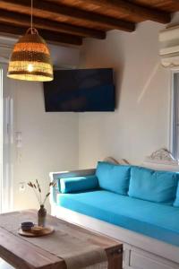 a living room with a blue couch and a table at Liogerma Residence in Serifos Chora