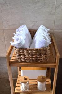 a basket of towels on a shelf in a bathroom at Liogerma Residence in Serifos Chora