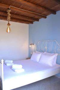 a blue bedroom with a bed with white pillows at Liogerma Residence in Serifos Chora
