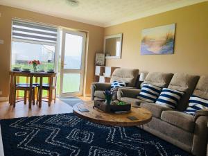 a living room with a couch and a table at The Phoenix by the Sea- 2 bedroom flat in hunny in Hunstanton