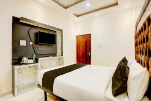 - une chambre avec un grand lit et une télévision dans l'établissement Super OYO Flagship SHIVA VALLEY HOTEL, à Varanasi