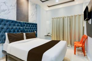 a bedroom with a large bed and a blue headboard at Super OYO Flagship SHIVA VALLEY HOTEL in Varanasi
