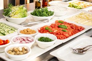 a buffet of food with tomatoes and other vegetables at NOVY Hotel in Zielona Góra