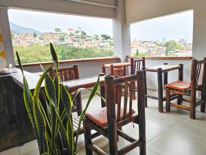 a balcony with chairs and a table and a window at La Mercedes Lite Hostal By MH in Cali