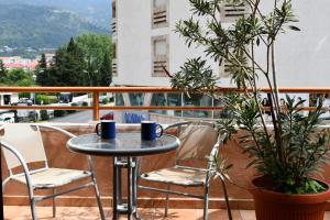 a table and chairs on a balcony with plants at So rooms city centre in Budva