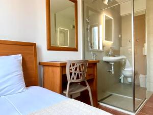 a bedroom with a bed and a sink and a shower at So rooms city centre in Budva