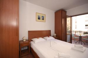 a bedroom with a large bed and a balcony at So rooms city centre in Budva
