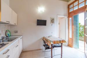 cocina con mesa y TV en la pared en Casetta al Lago, en Mezzegra