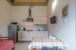 una pequeña cocina con mesa y nevera en Casetta al Lago, en Mezzegra