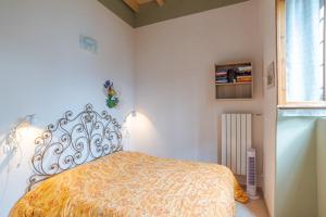 1 dormitorio con 1 cama con colcha amarilla en Casetta al Lago, en Mezzegra