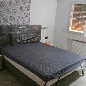 Ein Bett ist in einem Zimmer in Plastik eingewickelt. in der Unterkunft Appartement 1 in Hammamet