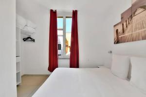 Schlafzimmer mit einem Bett und einem Fenster mit roten Vorhängen in der Unterkunft Nice 2 Rooms in the heart of Cannes in Cannes